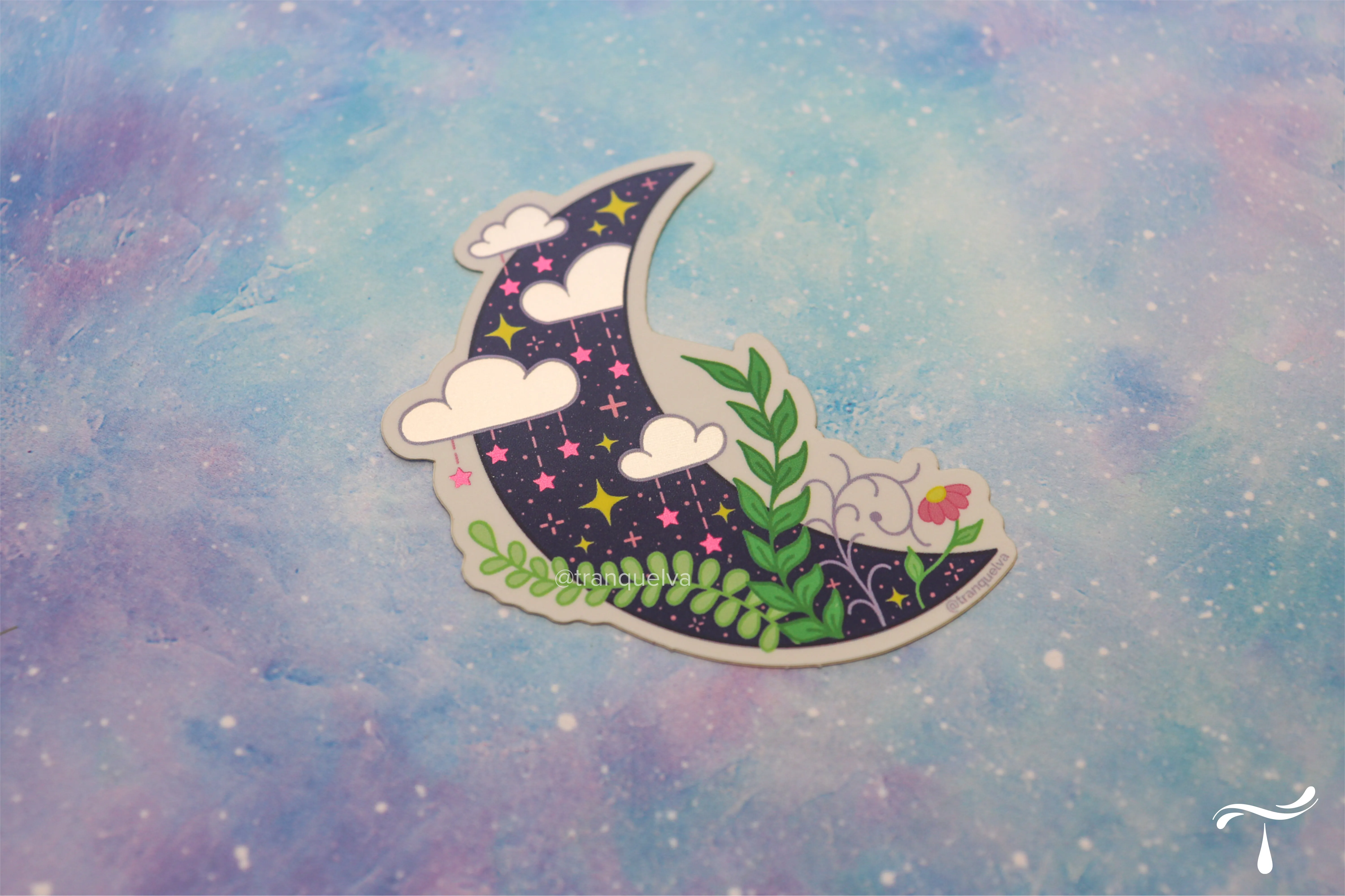 Die-cut sticker of a navy crescent moon with clouds, stars and leafy botanicals on a pastel galaxy background